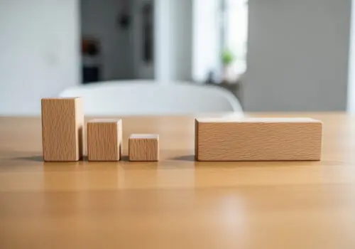 Symbolische Darstellung der Gesamtstrafenbildung: Drei einzelne Holzklötze sind größer als ein einzelner zusammengefasster Klotz.