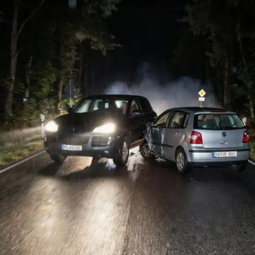 Aggressive Seitenkollision bei Nacht: Ein großes Auto rammt gezielt einen kleineren Wagen auf dunkler Landstraße.