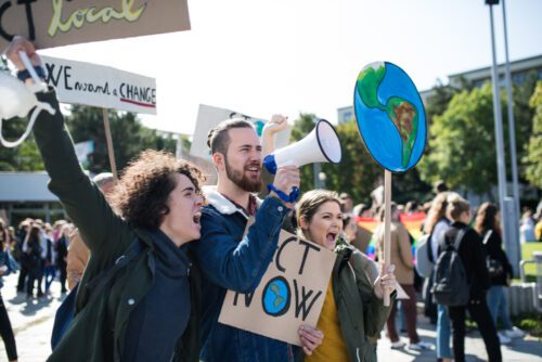 Klimaprotest mit Megaphon und Schildern.