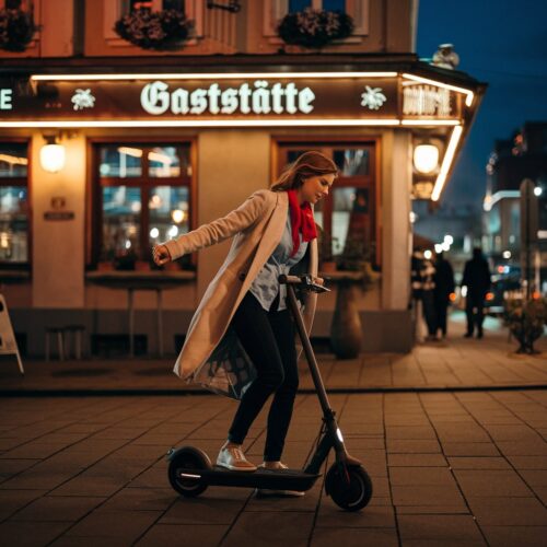 Frau verliert das Gleichgewicht auf E-Scooter vor beleuchteter Kneipe
